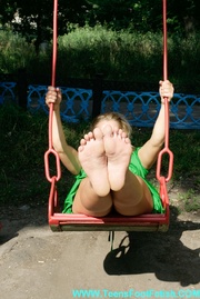Erotic pics of erotic smily blonde in green sexy dress showing her sexy feet on children's playground.