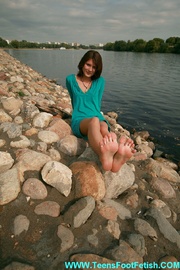 Sedcutively dressed brunette teen chick exposing her perfect legs while sitting on the bench.