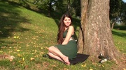 Beautiful teen babe in green dress posing under the tree and exposing sexy feet.