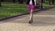 Amateur teen cutie in short pink miniskirt showing her sexy legs while sitting on the bench.