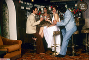 Seventies girl gets a free cocktail in a bar from two guys
